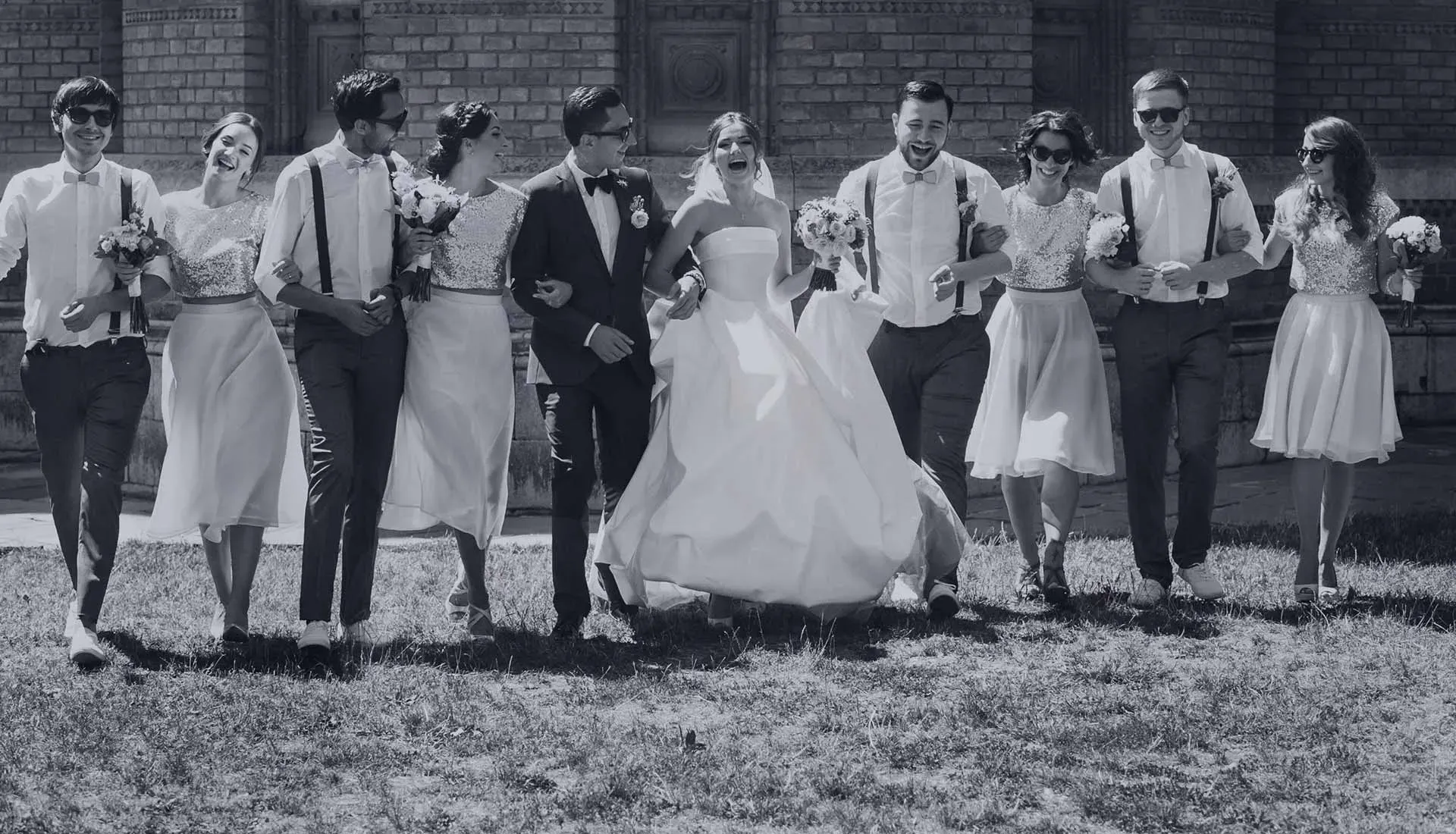 Hochzeitsgesellschaft mit Braut und Bräutigam beim gemeinsamen Spaziergang